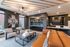 Contemporary lounge featuring a cozy seating area with stylish chairs and leather sofas, modern artwork, and a sleek built-in bar at Peer on 7th.