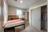 Cozy bedroom with stylish decor, featuring a comfortable bed, modern closet, and ample natural light.