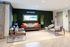 Chic living room with modern decor, featuring cozy seating, stylish pillows, and a vibrant green wall.