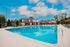 Luxurious poolside retreat with modern architecture and plush lounge chairs, perfect for relaxation under a clear blue sky.