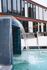 Luxurious apartment complex featuring a modern waterfall pool adjacent to sleek, contemporary architecture.