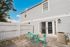 Charming outdoor patio with vibrant turquoise furniture, framed by a white picket fence and elegant gray siding.