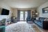 Inviting living room with modern decor, cozy seating, and abundant natural light through elegant double doors leading to a serene outdoor view.