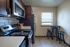 Charming kitchen with sleek dark wood cabinets, modern appliances, and a cozy dining nook with natural light.