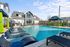 Inviting outdoor pool area featuring stylish loungers, vibrant green cabanas, and modern architecture, perfect for relaxation and entertainment.