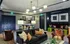 Elegant living room with chic decor, plush seating, vibrant cushions, and stylish artwork on walls, featuring a modern chandelier and ambient lighting.