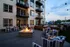 Chic outdoor patio with stylish striped seating and a cozy fire pit, perfect for evening gatherings.