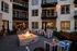 Charming courtyard with cozy fire pit surrounded by stylish striped chairs at a modern apartment complex, perfect for relaxing evenings.