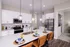 Elegant modern kitchen with sleek white cabinetry, stainless steel appliances, and a chic island featuring stylish pendant lighting.