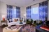 Inviting living room featuring a plush cream sofa, elegant patterned curtains, and vibrant decor accents for a cozy ambiance.