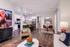 Modern open-concept living room with vibrant decor, stylish dining area, and a sleek kitchen with contemporary lighting.