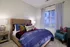 Cozy modern bedroom with elegant decor, featuring a plush bed, vibrant throw pillows, and a soft ambient light.