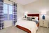 Inviting bedroom with plush bedding, stylish bedside lamps, and large window for ample natural light.