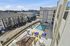 Vibrant apartment complex with a sunny pool deck, colorful lounge chairs, and elegant outdoor seating, perfect for relaxation in a lively urban setting.