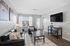 Contemporary living room with sleek leather sofas, hardwood flooring, and a wall-mounted flat-screen TV, providing a bright and airy atmosphere.