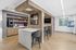 Modern communal space with sleek wood accents, cozy seating, and a stylish coffee bar, perfect for social gatherings or relaxation.