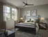 Chic bedroom featuring a cozy queen-sized bed with elegant linens, modern ceiling fan, and large windows inviting natural light.