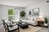 Inviting living room with modern decor, cozy white sofa, elegant indoor plants, and large window for abundant natural light.