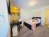 Chic bedroom featuring a cozy bed with stylish pillows, elegant desk area, and ample closet space.