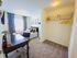 Bright bedroom with cozy bed, sleek desk, and spacious walk-in closet, perfect for modern living.