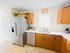 Modern kitchen with stainless steel appliances, warm wooden cabinets, and a bright window for natural lighting.