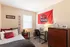 Cozy bedroom with university theme decor, featuring a comfortable bed, study desk, and ample storage.