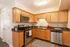 Inviting modern kitchen with stainless steel appliances, elegant wooden cabinetry, and sleek granite countertops.