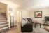 Inviting living room with modern decor, cozy seating, and a stylish staircase creating a warm atmosphere.