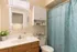 Bright and inviting bathroom with elegant white cabinetry, stylish blue shower curtain, and modern accents.