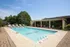 Inviting outdoor swimming pool area featuring comfortable lounge chairs and lush greenery, perfect for relaxation and leisure.
