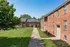 Charming brick apartment buildings surrounded by lush greenery, offering a serene and inviting atmosphere.