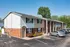 Charming two-story apartment building with modern exterior, spacious parking, and vibrant landscaping for convenient living.