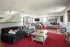 Chic and spacious living room featuring stylish plaid sofas, vibrant red accents, and modern decor with ample natural light.