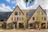 Charming urban townhouses with modern brick facade and colorful doors, enhanced by lush landscaping and a vibrant neighborhood feel.