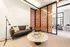 Chic modern living area with a cozy dark sofa, elegant round coffee table, and stylish decorative divider panel.