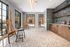 Bright and modern art studio with large windows, easels, and stylish cabinetry, perfect for creative inspiration.