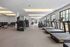 Modern fitness center with state-of-the-art equipment, including treadmills, ellipticals, and weight benches, offering a sleek and inviting workout environment.