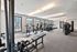 Modern fitness center with abundant natural light and state-of-the-art equipment, offering a dynamic workout experience.