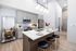 Sleek modern kitchen with stylish gray cabinets, elegant breakfast bar, and chic pendant lighting.