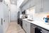 Modern kitchen with sleek cabinetry, stainless steel appliances, and chic backsplash in a well-lit apartment.