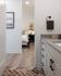 Contemporary apartment showcasing a sleek bathroom leading into a cozy bedroom, adorned with modern art and elegant lighting.