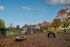 Charming residential community with vibrant autumn foliage, featuring a fenced outdoor recreation area with a rustic clubhouse and serene landscape views.