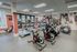 Modern fitness center featuring state-of-the-art exercise equipment, including treadmills, elliptical machines, and stationary bikes, set in a vibrant and welcoming atmosphere.