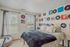 Charming bedroom with vintage record-themed decor and lush natural light from large windows, perfect for music lovers seeking a cozy retreat.