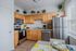 Bright and inviting kitchen with modern stainless steel appliances, natural wood cabinetry, and charming decor accents. Large window fills the space with natural light.