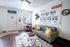 Charming living room with stylish decor, cozy seating, and floor plans displayed on the wall, creating a welcoming and inviting atmosphere.