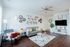 Bright and inviting living room with modern decor, featuring a cozy gray sofa, stylish accent chair, and elegant wall art creating a welcoming ambiance.