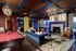 Elegant lounge with a luxurious fireplace, vibrant art, and cozy seating, enhanced by a sophisticated billiard table and inviting ambiance.