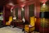 Luxurious study area with elegant red and gold decor, featuring vintage chairs, a classic wooden desk, and ambient lighting.