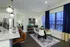 Modern open-concept kitchen and dining area with sleek marble countertops, elegant lighting, and large windows offering ample natural light.